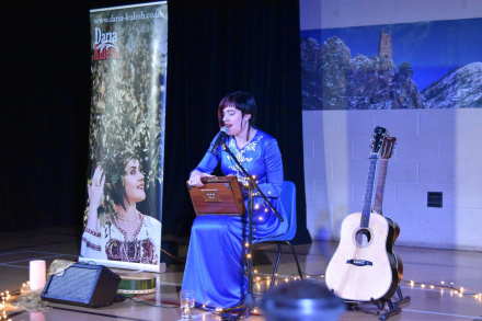 The folksinger Daria Kulesh on stage in a blue dress.