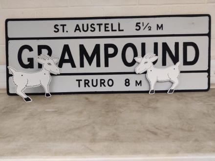 Two plastic goats are attached to the Grampound sign.