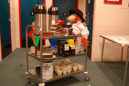 A tea trolley packed with biscuits, beer, wine, and a toy monkey.