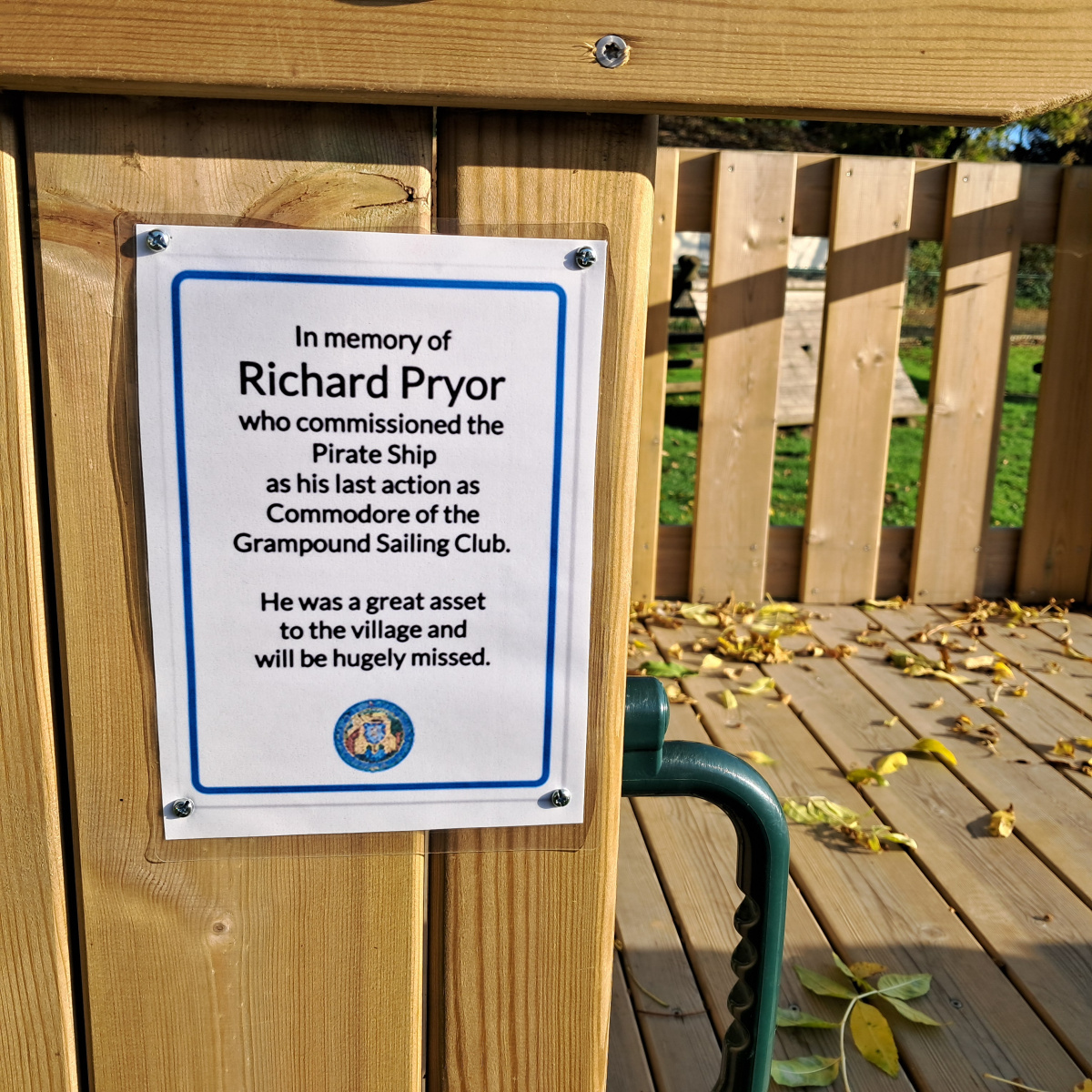 A memorial notice attached to the wooden pirate shape play area.